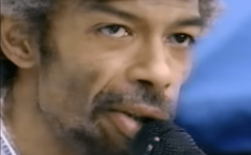 Gil Scott-Heron, graying, at microphone 1994